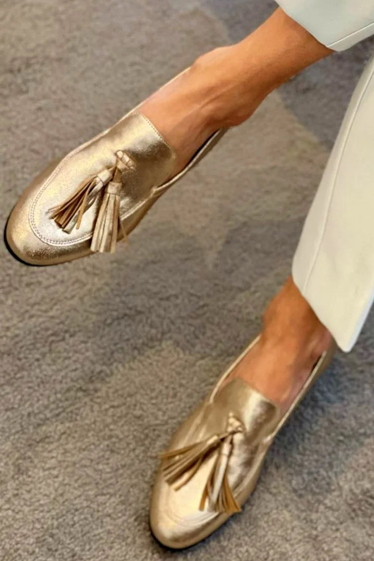 Women's metallic gold loafers with tassel detail and round toes