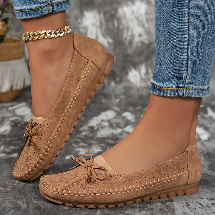 Women's perforated loafers with decorative bows and flat segmented soles