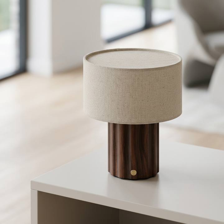 Dark brown table lamp with a cream drum shade on a bedside table