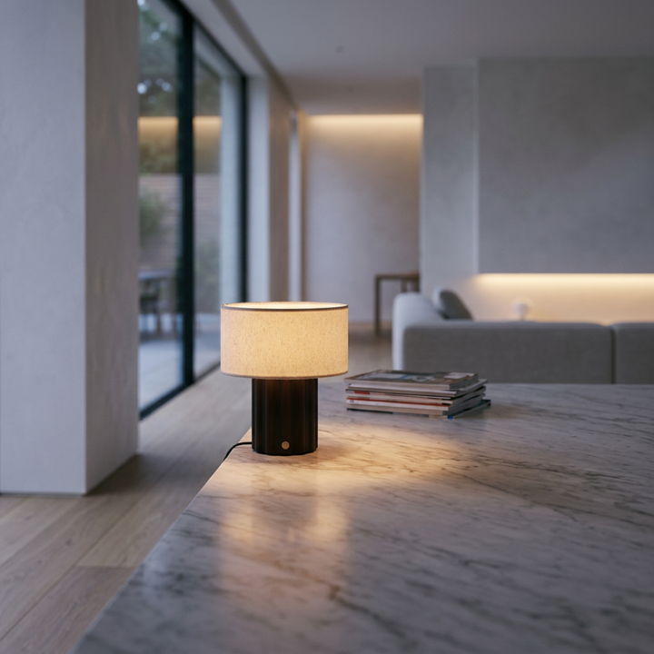 Dark brown table lamp with a cream drum shade on a bedside table