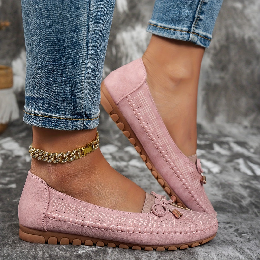 Women's perforated loafers with decorative bows and flat segmented soles