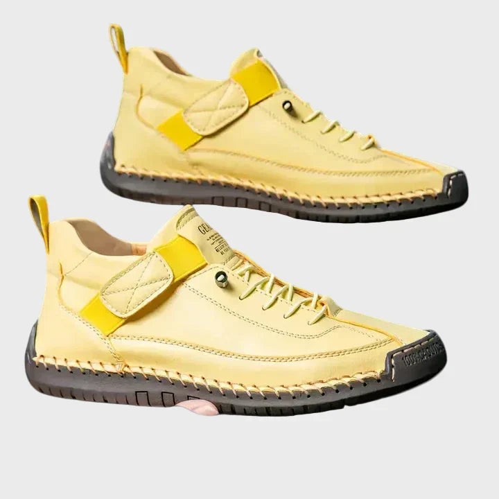 Orthopedic sneakers with white upper and beige sole, worn with jeans