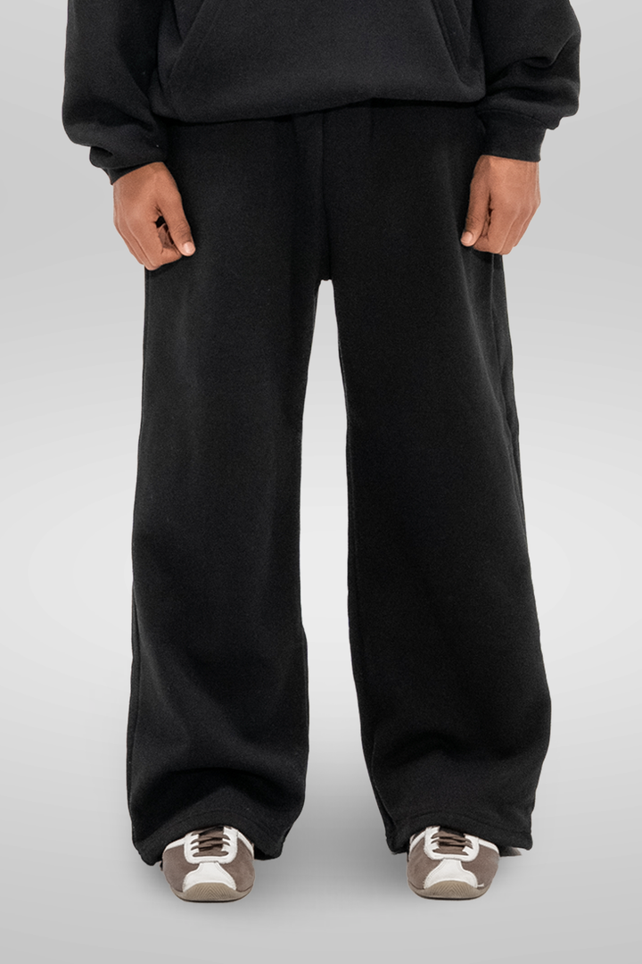 Man wearing black wide-leg sweatpants with an elastic waistband and side pockets