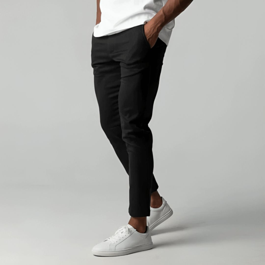 Men's slim tapered cropped chino pants shown in black and navy with side pockets and button closure