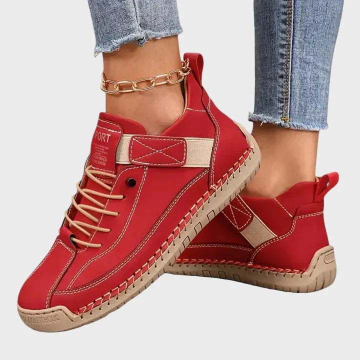 Orthopedic sneakers with white upper and beige sole, worn with jeans