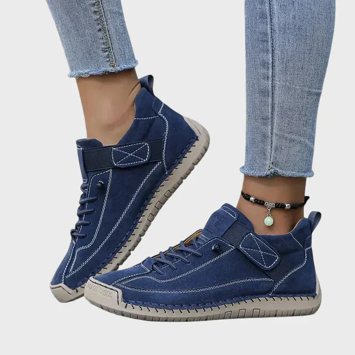 Orthopedic sneakers with white upper and beige sole, worn with jeans