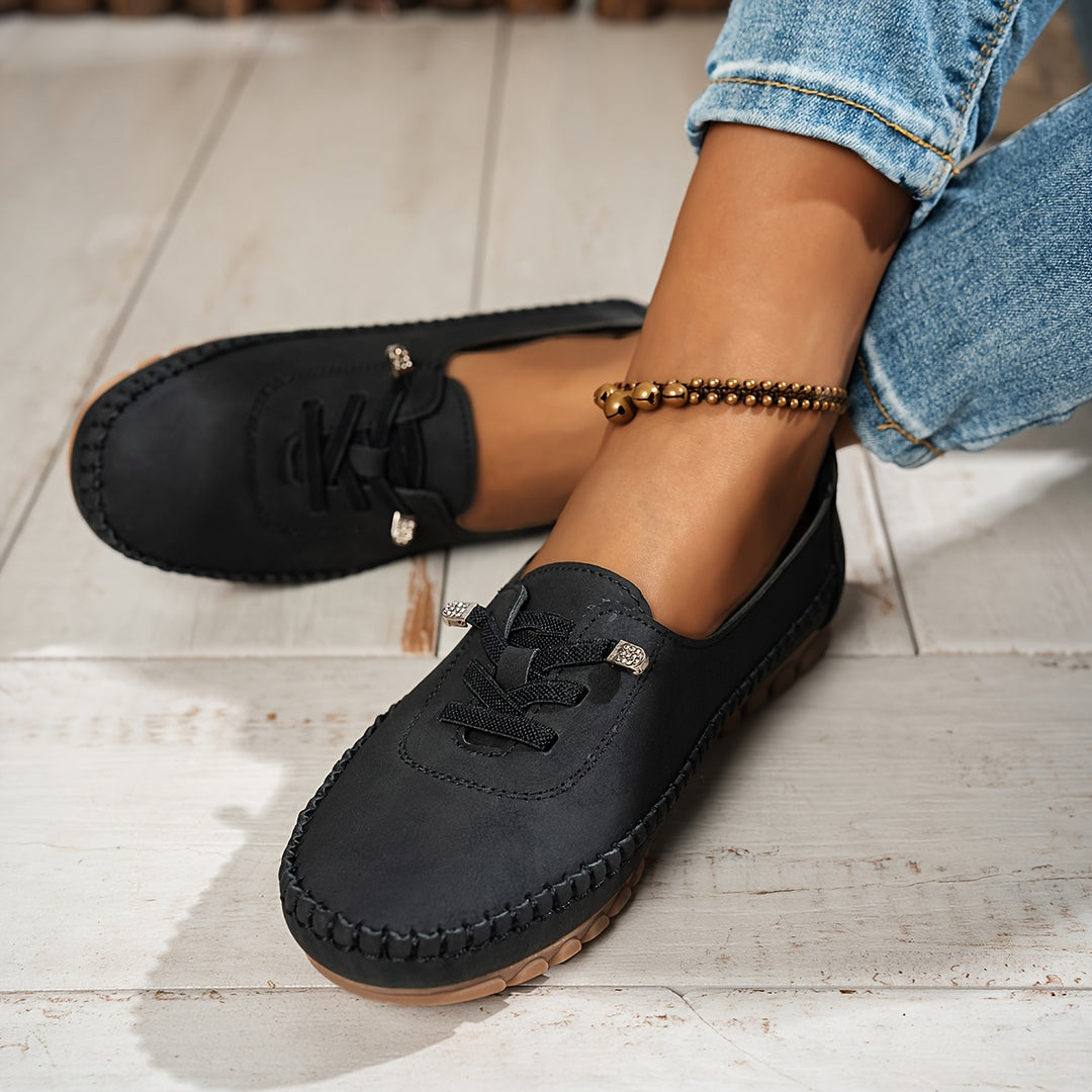 Women's low-profile lace-up moccasin shoes with stitched trim and flat textured soles