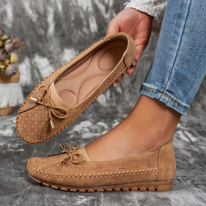 Women's perforated loafers with decorative bows and flat segmented soles
