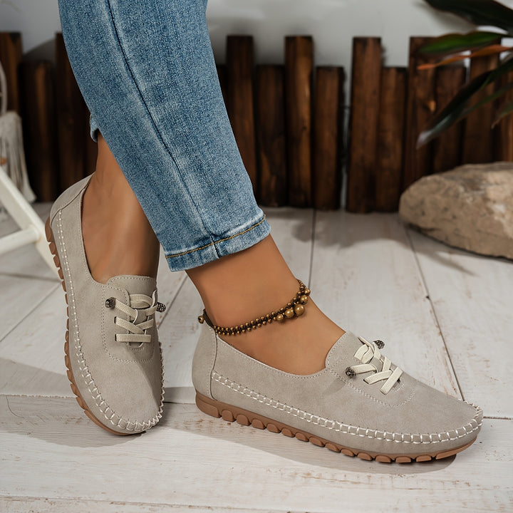 Women's low-profile lace-up moccasin shoes with stitched trim and flat textured soles