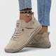 Orthopedic sneakers with white upper and beige sole, worn with jeans