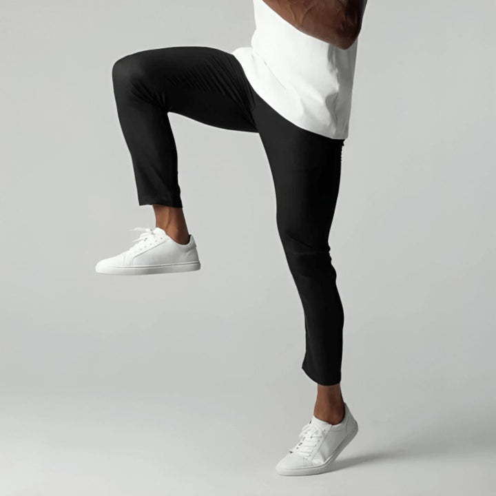 Men's slim tapered cropped chino pants shown in black and navy with side pockets and button closure