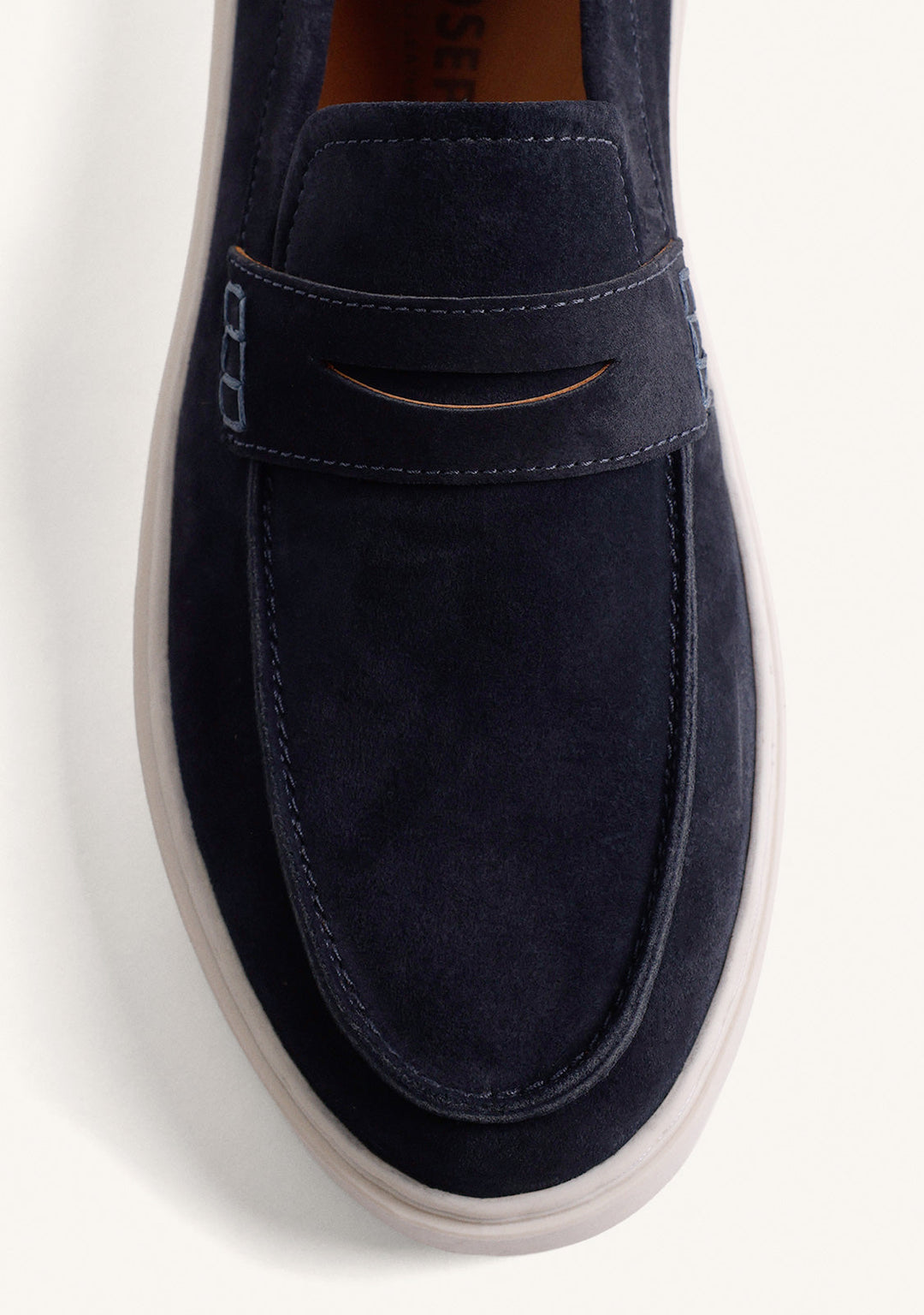Navy penny loafers with moc toe stitching and light platform soles