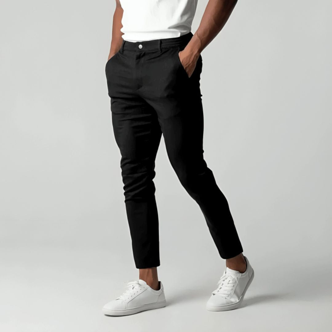 Men's slim tapered cropped chino pants shown in black and navy with side pockets and button closure