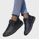 Orthopedic sneakers with white upper and beige sole, worn with jeans
