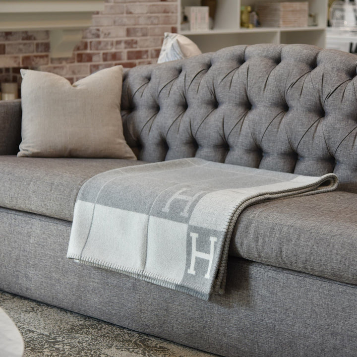 Folded rectangular throw blanket with contrasting blocks and letter motifs
