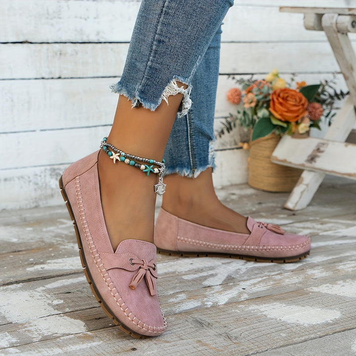 Women's slip-on tassel loafers with moccasin stitching and flat textured soles