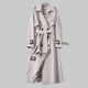 Women's long belted double-breasted trench coat with lapel collar and buckle cuffs