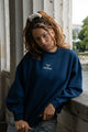 Women's navy crewneck sweatshirt with raised chest logo and ribbed trims