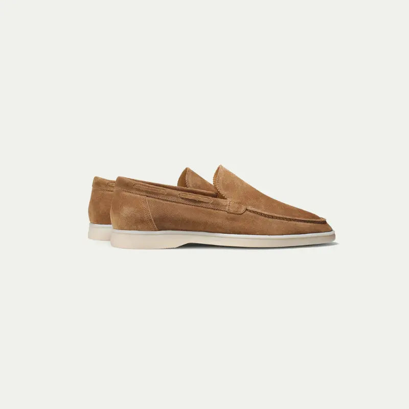 Men's brown slip-on loafers with moc toe stitching and white soles