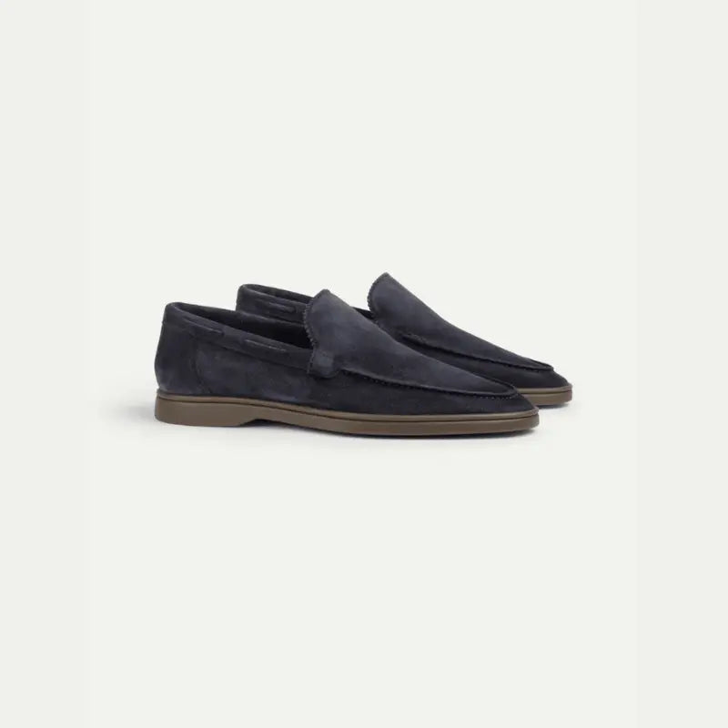 Men's navy penny loafers with almond toes and flat brown soles