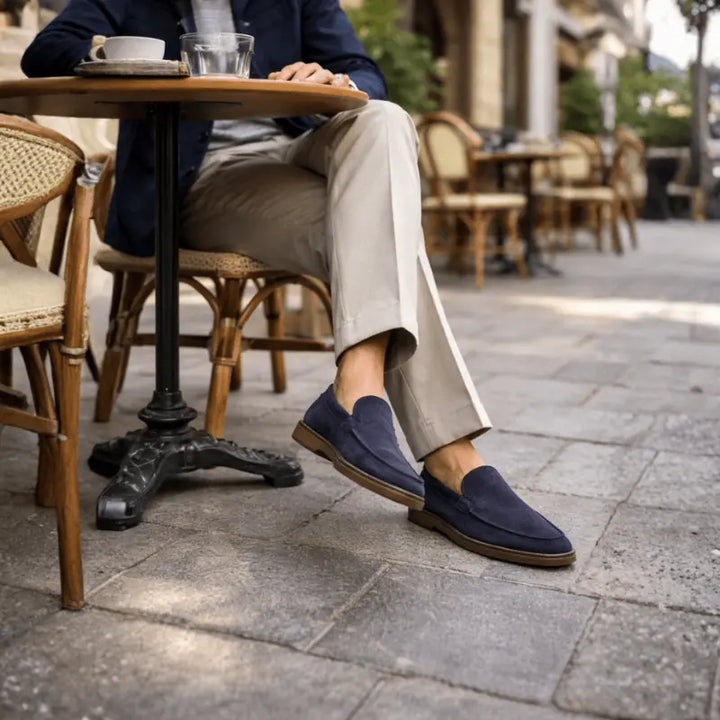 Men's navy penny loafers with almond toes and flat brown soles