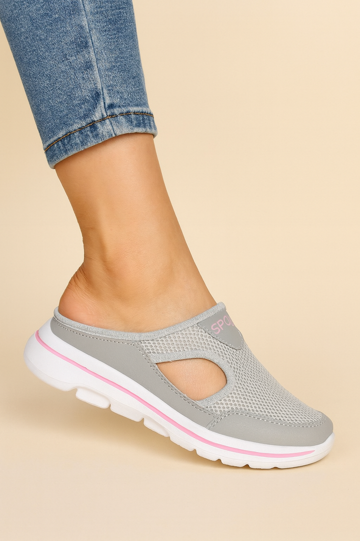 Women's orthopaedic slippers in black mesh and white sole, worn on bare feet