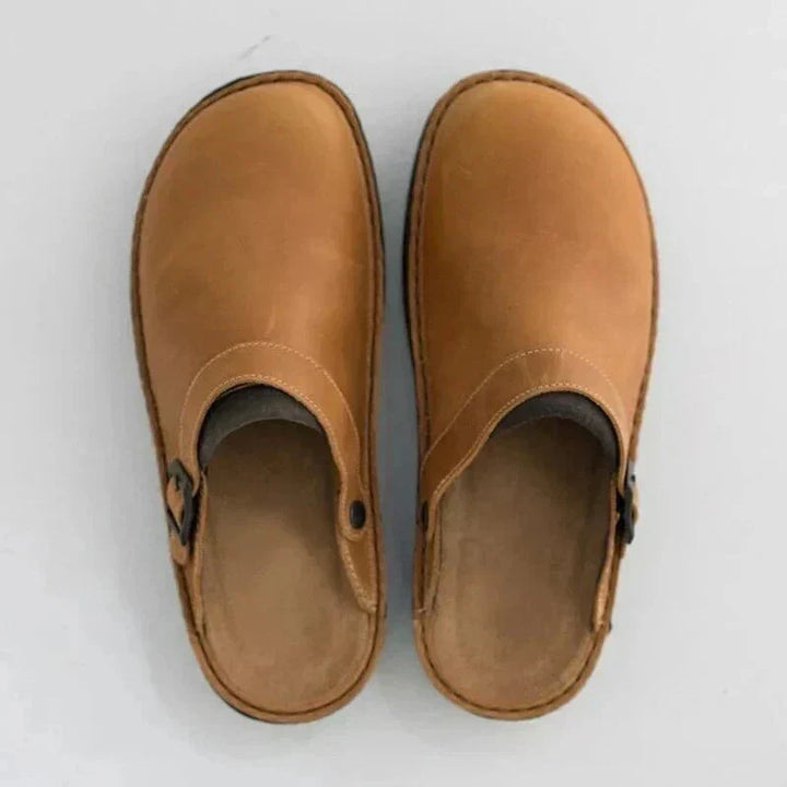 Women's tan and brown leather slip-on clogs with buckle strap