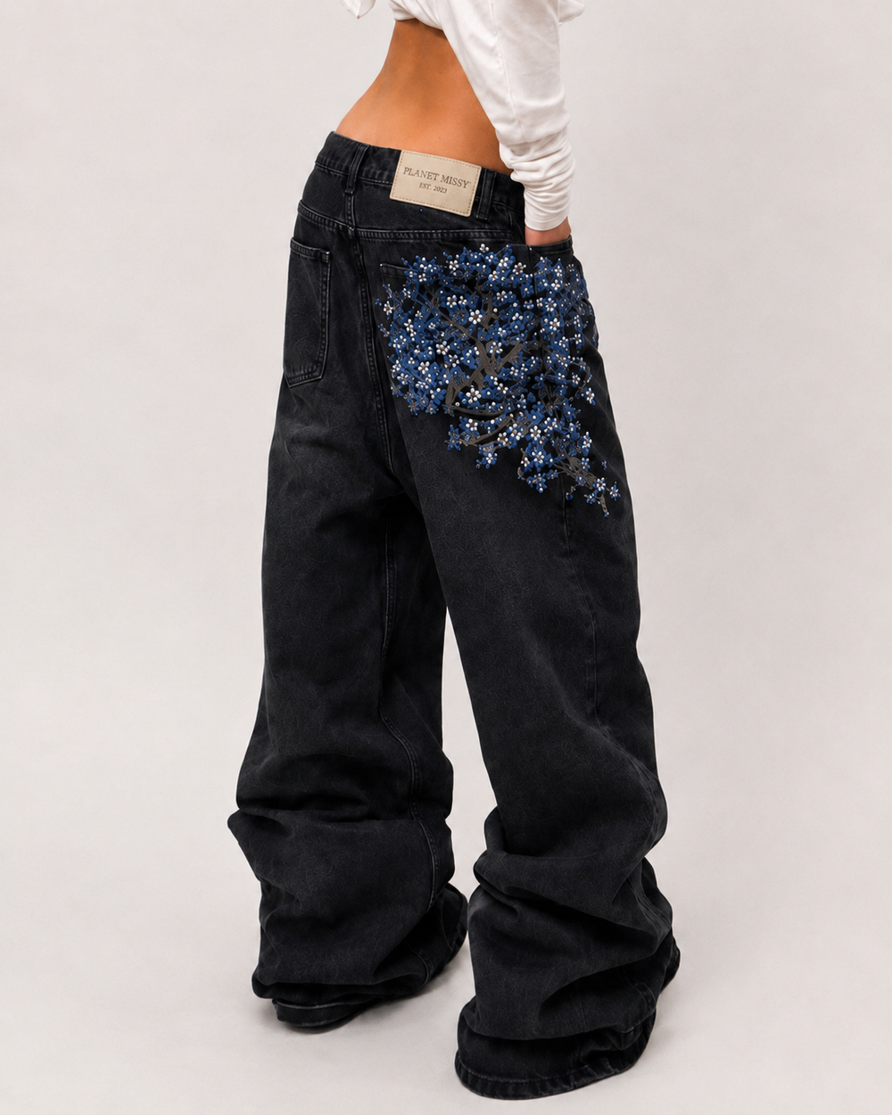 Women's black wide-leg jeans with blue floral embroidery