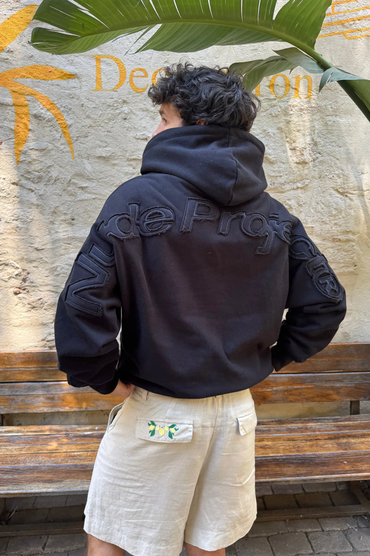 Black hooded sweatshirt with raised lettering on the back and sleeves