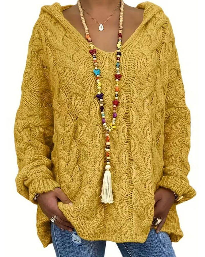 Women's hooded cable knit sweater with long sleeves and oversized fit