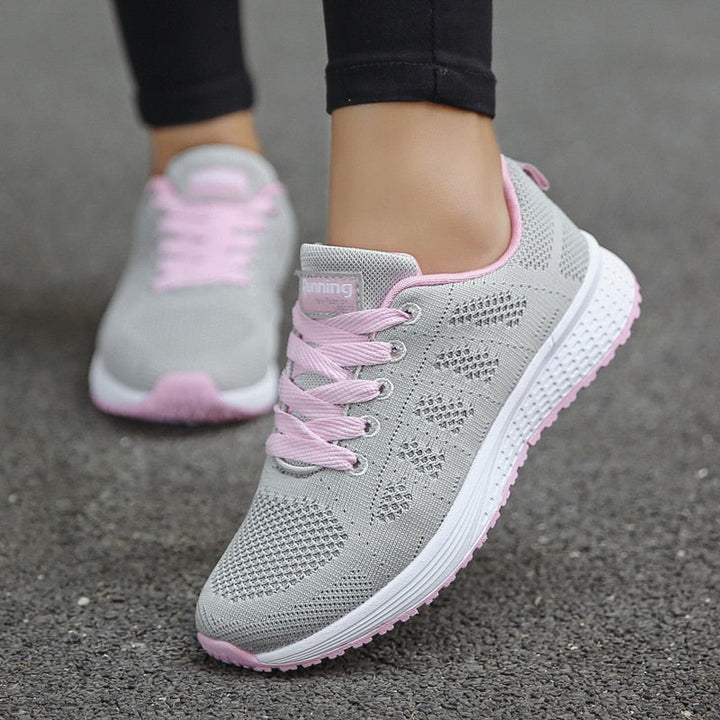Women's low-top lace-up sneakers with textured upper and flat sole