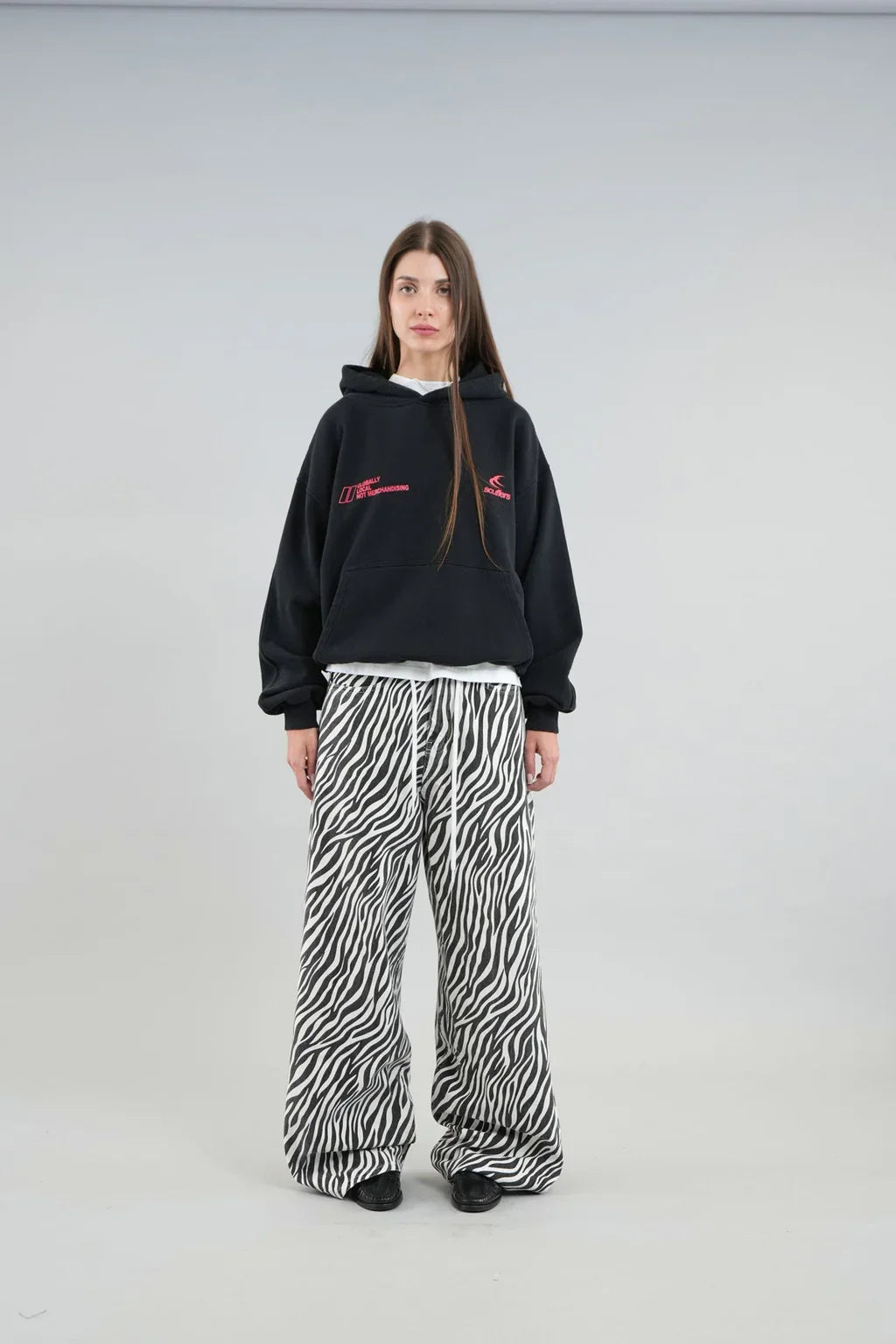 Model wearing an oversized graphic pullover hoodie with hood, long sleeves and kangaroo pocket