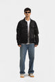 Men's black button-front denim jacket with pointed collar and chest pockets