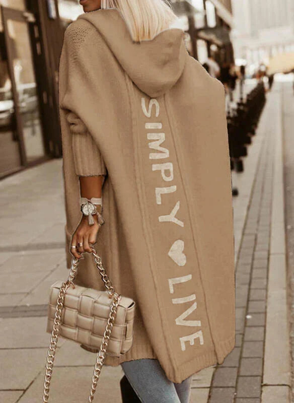 Woman wearing a longline hooded knit cardigan with graphic back lettering