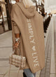 Woman wearing a longline hooded knit cardigan with graphic back lettering