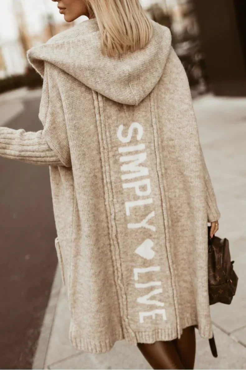 Woman wearing a longline hooded knit cardigan with graphic back lettering