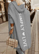 Woman wearing a longline hooded knit cardigan with graphic back lettering