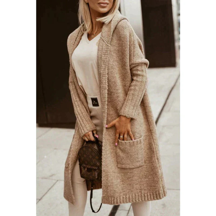 Woman wearing a longline hooded knit cardigan with graphic back lettering