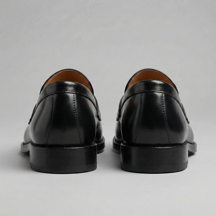 Men's black penny loafers with glossy finish, almond toe and low heel