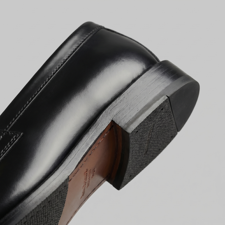 Men's black penny loafers with glossy finish, almond toe and low heel