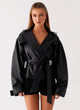 Women's black belted trench jacket with wide lapels and long sleeves