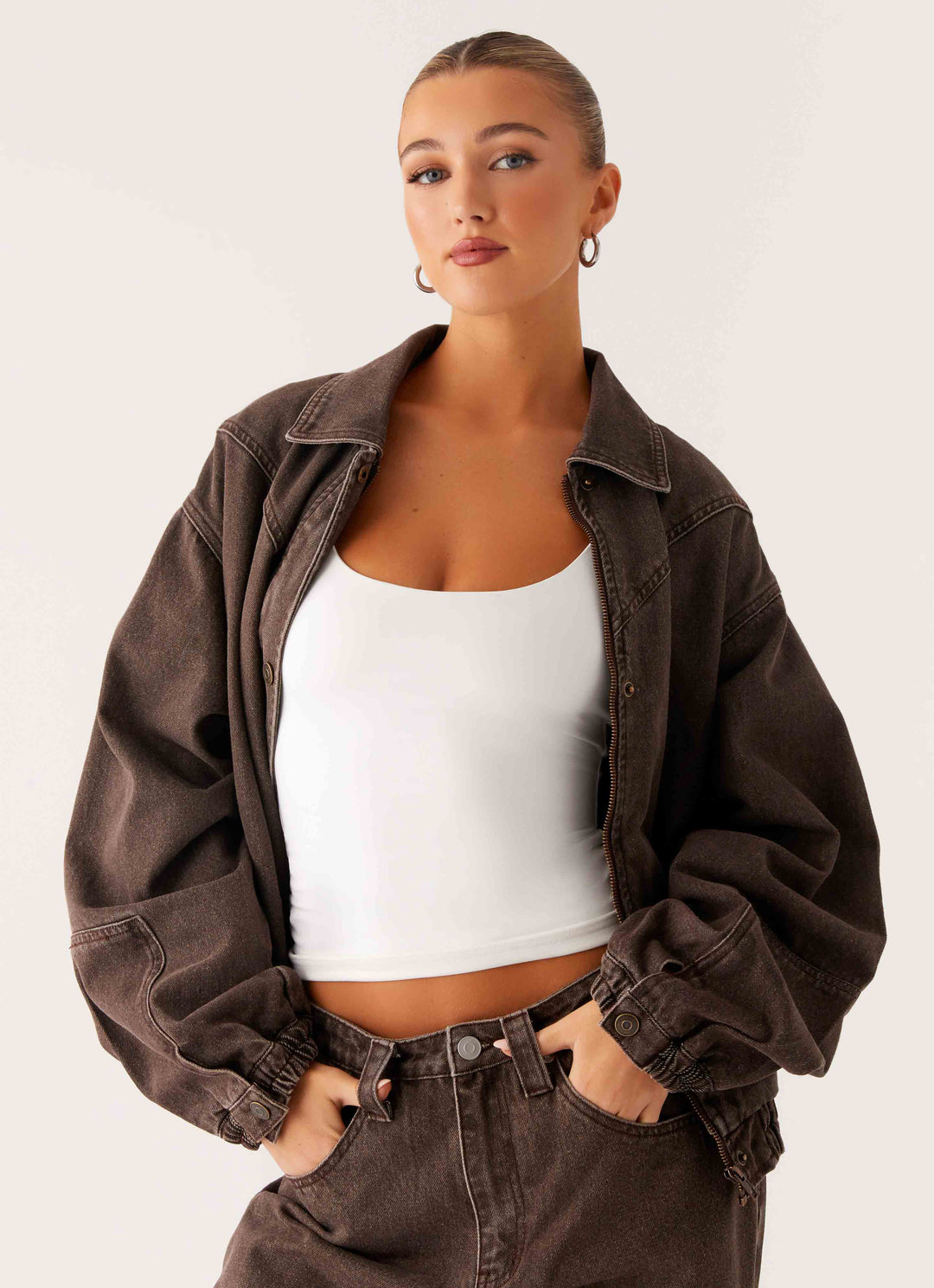 Women's brown washed denim bomber jacket with cropped fit and long sleeves