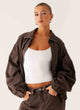 Women's brown washed denim bomber jacket with cropped fit and long sleeves