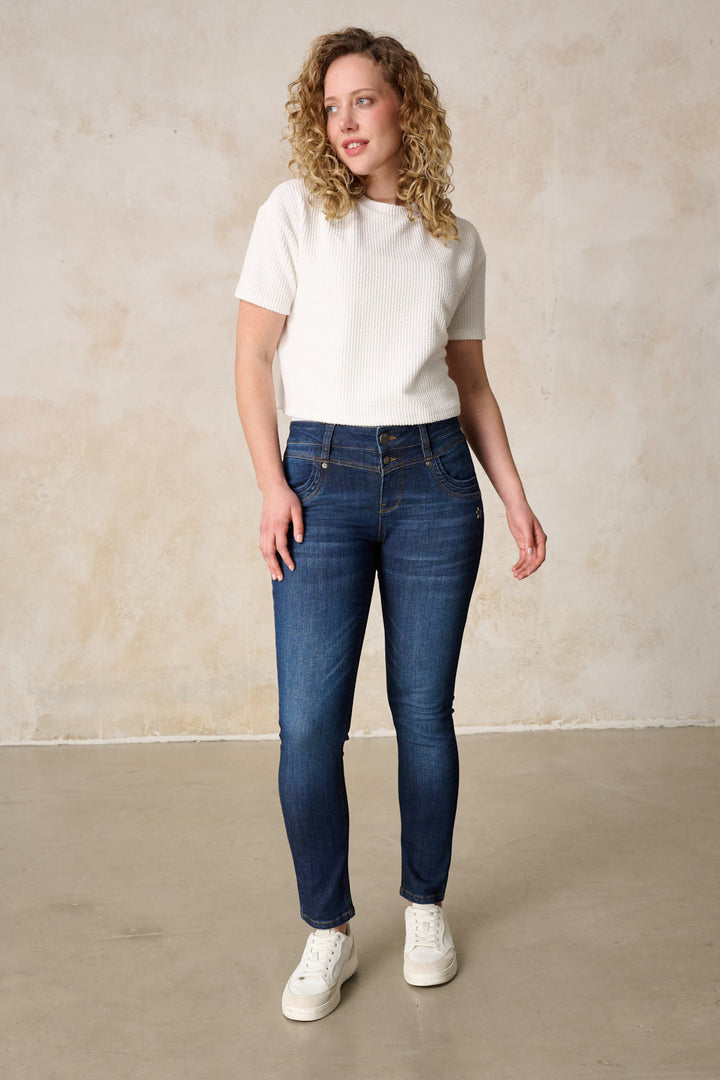 Women's dark blue slim fit jeans with mid-rise button fly and five pockets