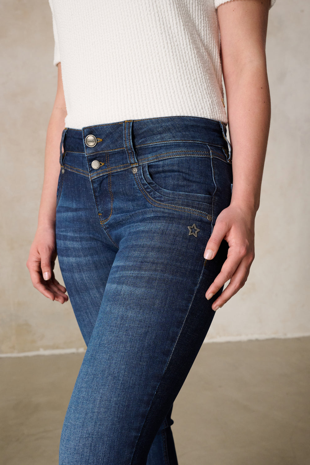 Women's dark blue slim fit jeans with mid-rise button fly and five pockets