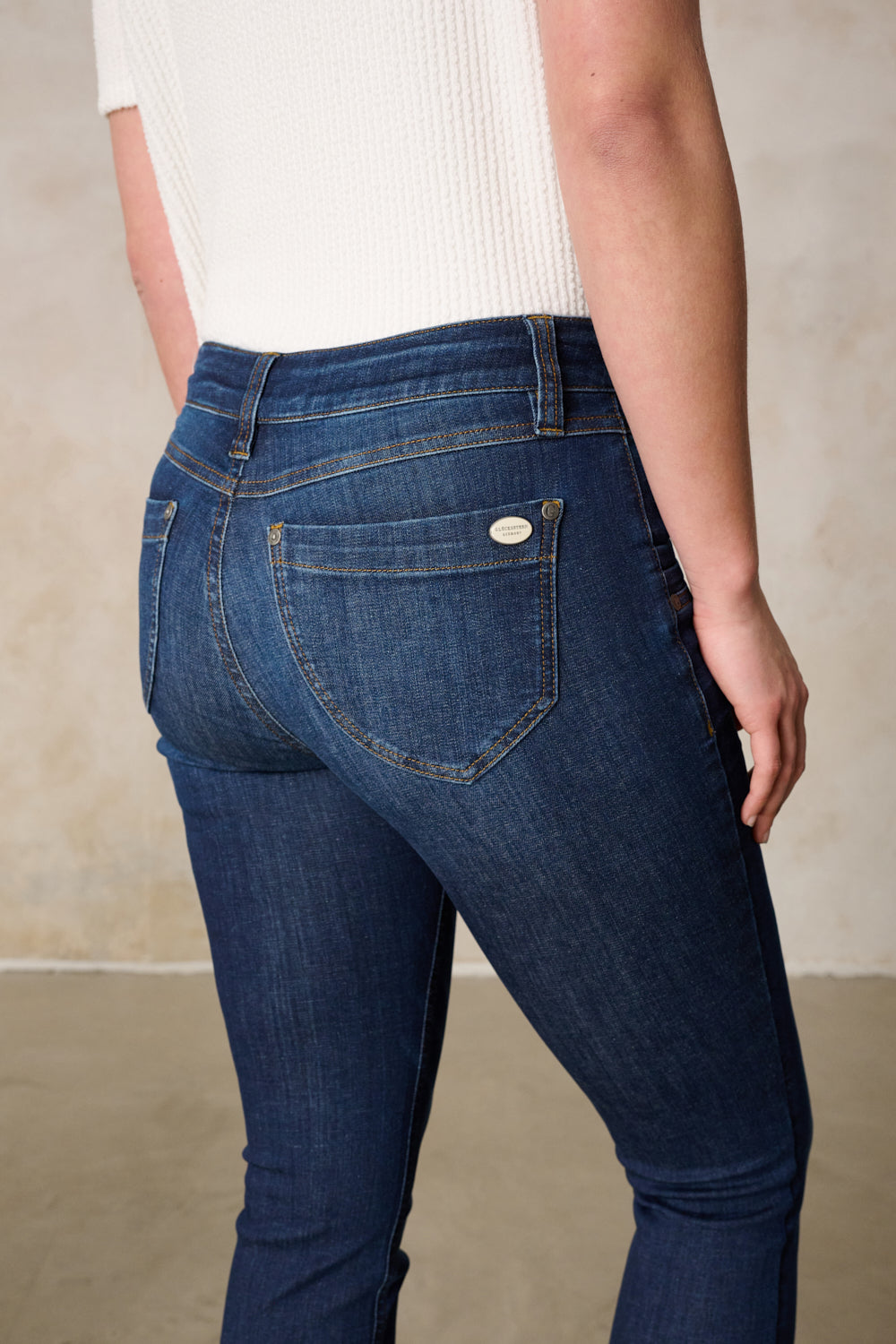 Women's dark blue slim fit jeans with mid-rise button fly and five pockets