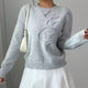 Women's crew neck sweater with long sleeves and raised floral front detail