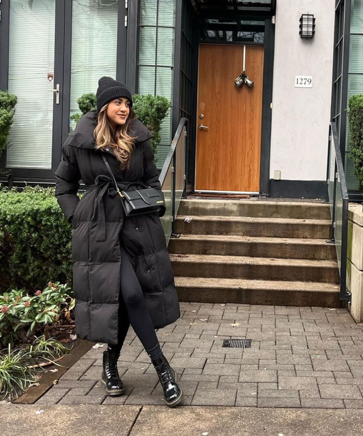 Women's black long belted puffer coat with raised collar