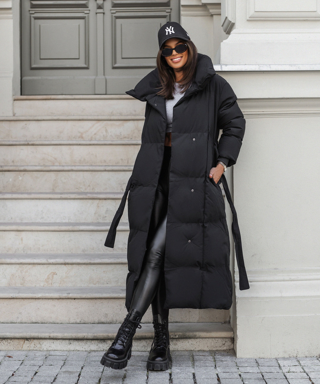 Women's black long belted puffer coat with raised collar