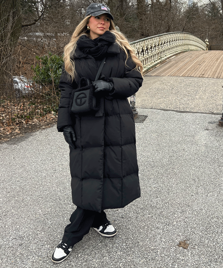 Women's black long belted puffer coat with raised collar